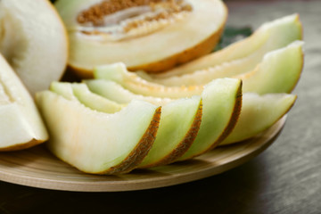 Slices of ripe melons on table close up