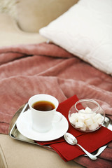Cup of tea on sofa in living room