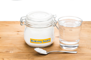Baking soda in jar, spoonful and glass of water for multiple hol