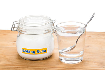Baking soda in jar, spoonful and glass of water for multiple hol