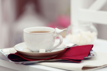 Cup of tea on chair in room