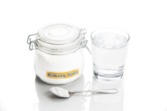 Baking soda in jar, spoonful and glass of water for multiple hol