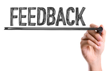 Hand with marker writing the word Feedback