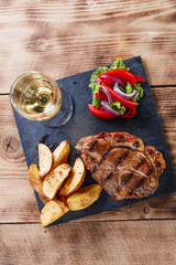 pork steak with fried potatoes and salad