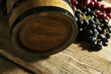 Old wine barrel and grape on wooden background