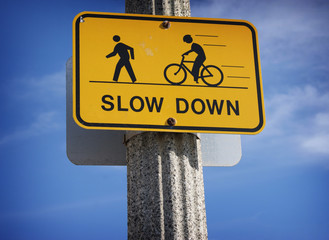 slow down road sign with bicycle