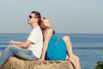 Loving couple sitting on the beach at the day time.