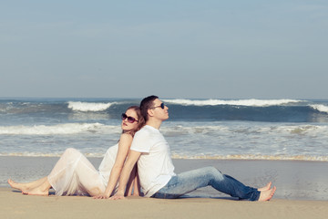 Loving couple sitting on the beach at the day time.