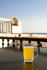 Glass of beer with lemon near the sea.