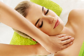 Young smile relaxed woman is massaged