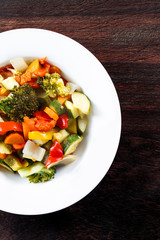 Cooked Roasted Vegetables stewed Tomatoes, Carrots, Peppers, Courgettes, brocoli, onion on plates.