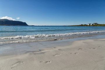 Footstep in the sand on a beach with some waves rolling in