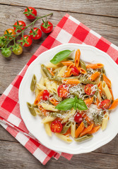 Colorful penne pasta with tomatoes and basil