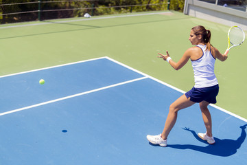 Fototapeta na wymiar Beautiful female tennis player in action
