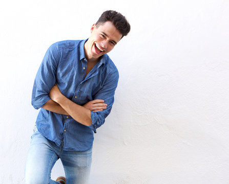 Cheerful young man in blue shirt laughing
