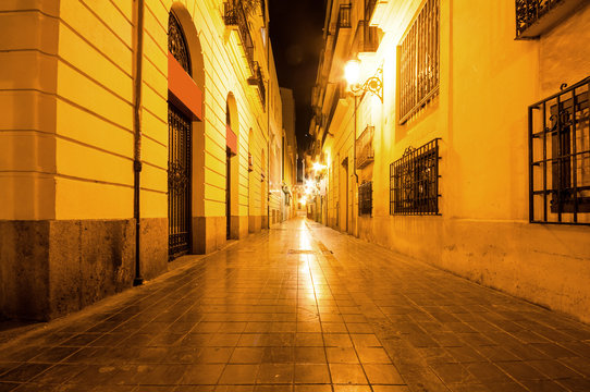 Narrow street at night in the old town in Valencia, Spain