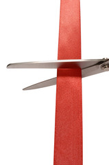 Scissors cutting red ribbon or tape close up closeup isolated on white background photo vertical