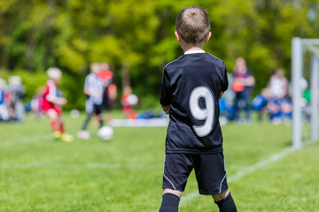Young boy watching a kids soccer match