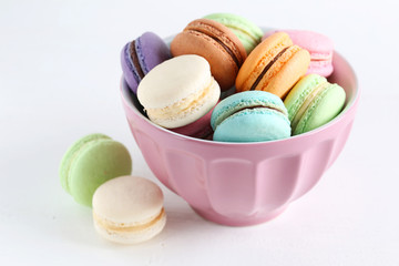 French colorful and tasty macarons in bowl on wooden table