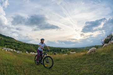 Fototapeta na wymiar young woman riding her bike on a rural trail