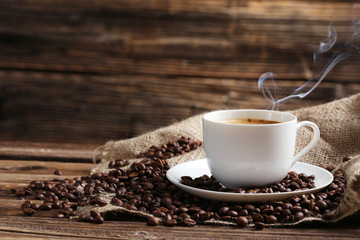 Tasse de café avec des grains de café sur un fond en bois marron