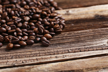 Roasted coffee beans on a brown wooden background
