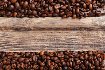 Roasted coffee beans on a brown wooden background