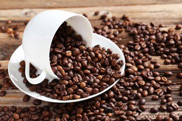 Fototapeta premium Coffee beans in cup on a brown wooden background