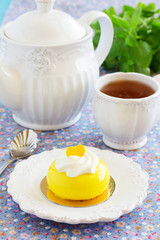 Cakes with mango and passion fruit with cream in the mirror glaze. Selective focus.