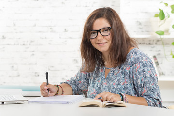a student with eyeglasses working in his office © Philipimage