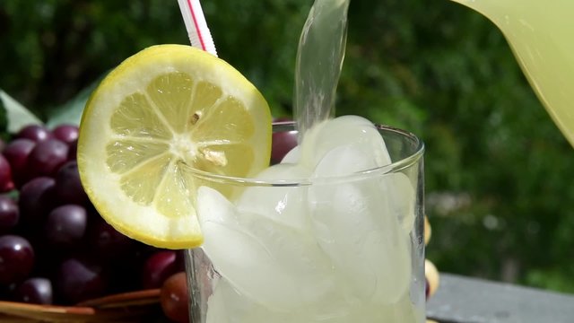 Pouring lemonade on a patio slow motion