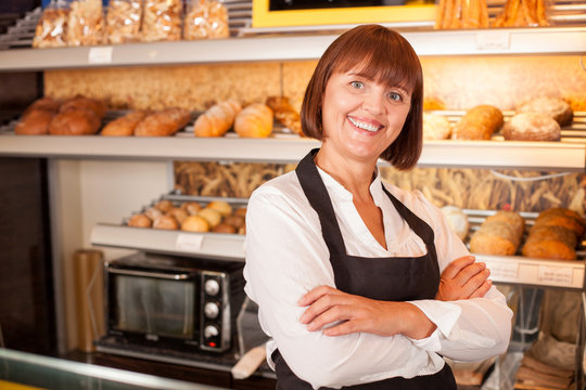 Cheerful female baker is presenting her pastry