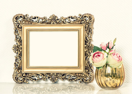 Golden baroque picture frame and roses flowers bouquet. Retro st