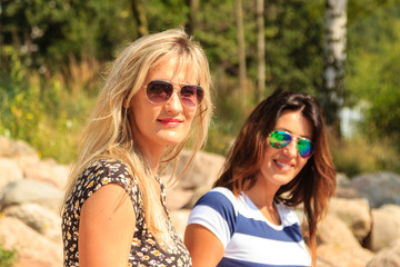 Happy women sun tanning and relaxing on beach.