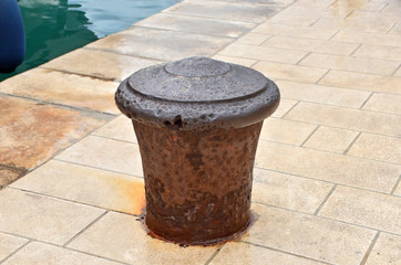 Naklejka premium Old mooring bollard and boat in port, Croatia