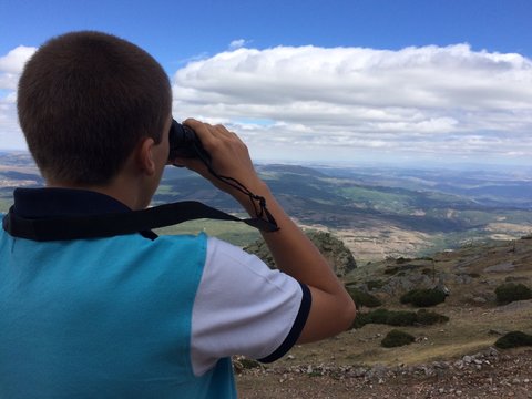 joven observando el paisaje con los prismaticos