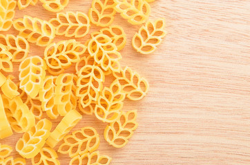Close-up of wheat shaped pasta on wooden background