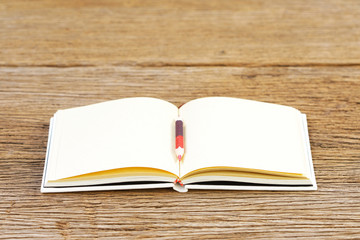 Notebook  and color pencil on wooden table