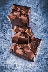 Giftboxes packed in crumpled glittery paper on scratched metalli
