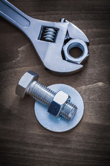 Adjustable key bolt washer screw-nut and bolt on wooden backgrou