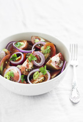 fresh salad with tomatoes in a white bowl on a light surface