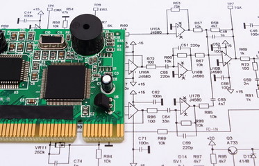 Printed circuit board lying on diagram of electronics, technology