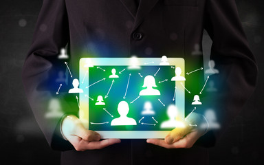 Young person presenting tablet with green social media icons