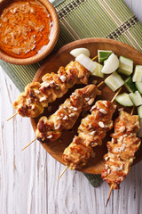 Chicken satay with a delicious peanut sauce closeup. vertical top view
