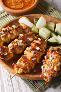 Chicken satay with peanut sauce and fresh salad closeup. vertical
