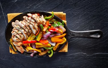 Photo sur Plexiglas Plats de repas mexican grilled chicken fajitas in iron skillet shot from overhead on dark slate