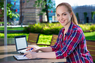 beautiful teenage student or school girl doing homework in park