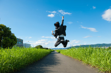 道路でジャンプをするスーツのビジネスマン