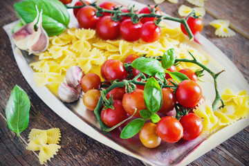 fresh organic cherry tomatoes and paste with basil garlic on a dark background