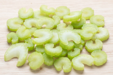 Heap of sliced celery, on wood background.